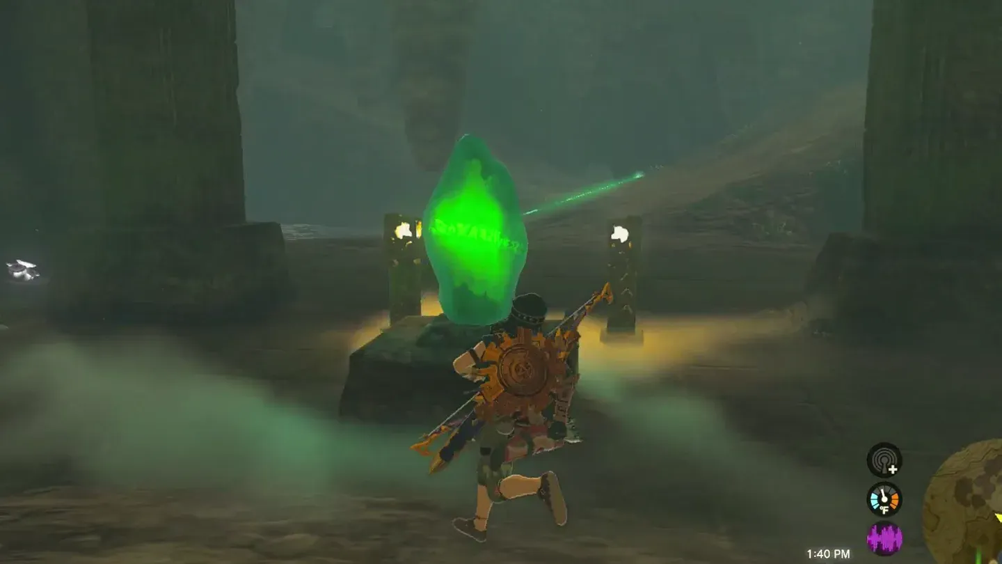 Link lifting the green crystal off its pedestal in the cave