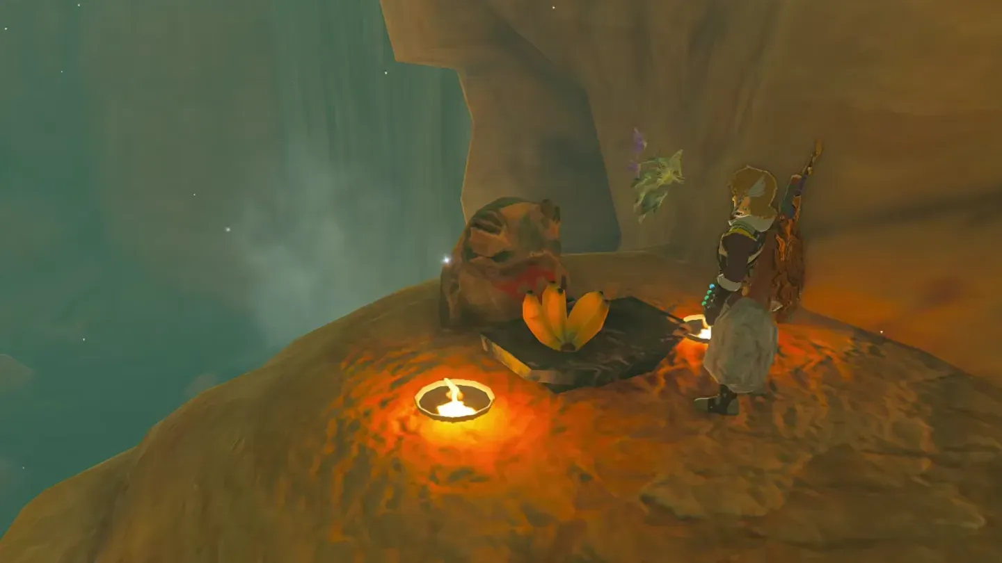Link beside a frog statue with a banana on the dish and a candle in front