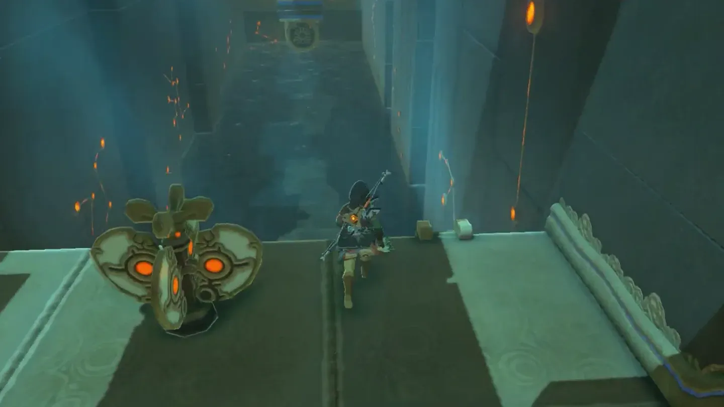 Link walking past an orange mechanical contraption toward the flooded hallway