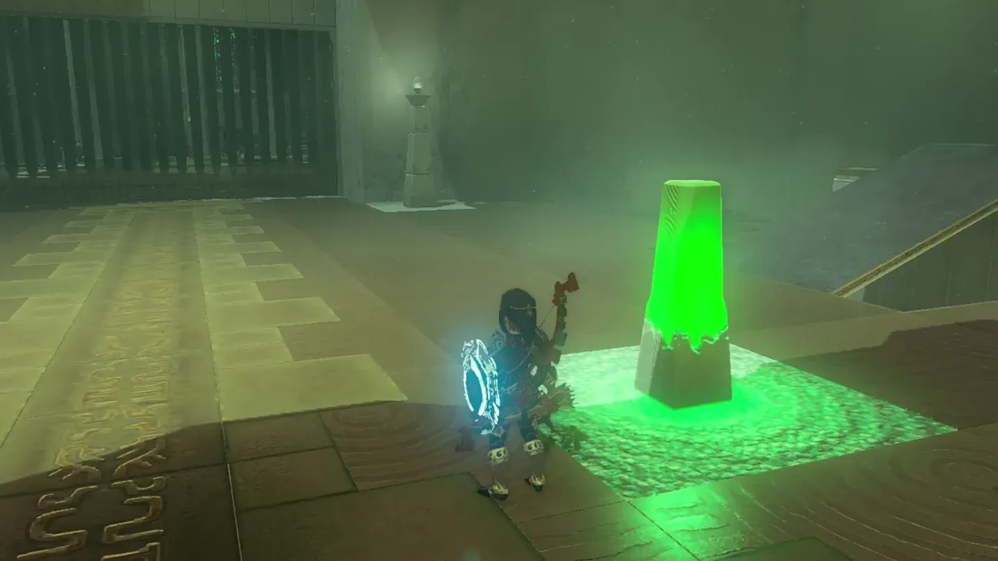 Link striking the glowing green switch pillar