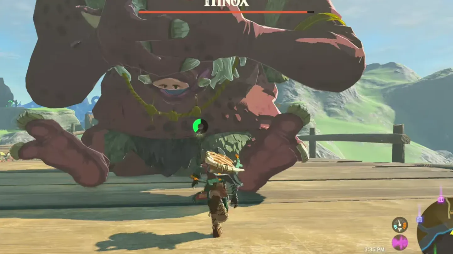 Link running under a Hinox toward the gap between its legs