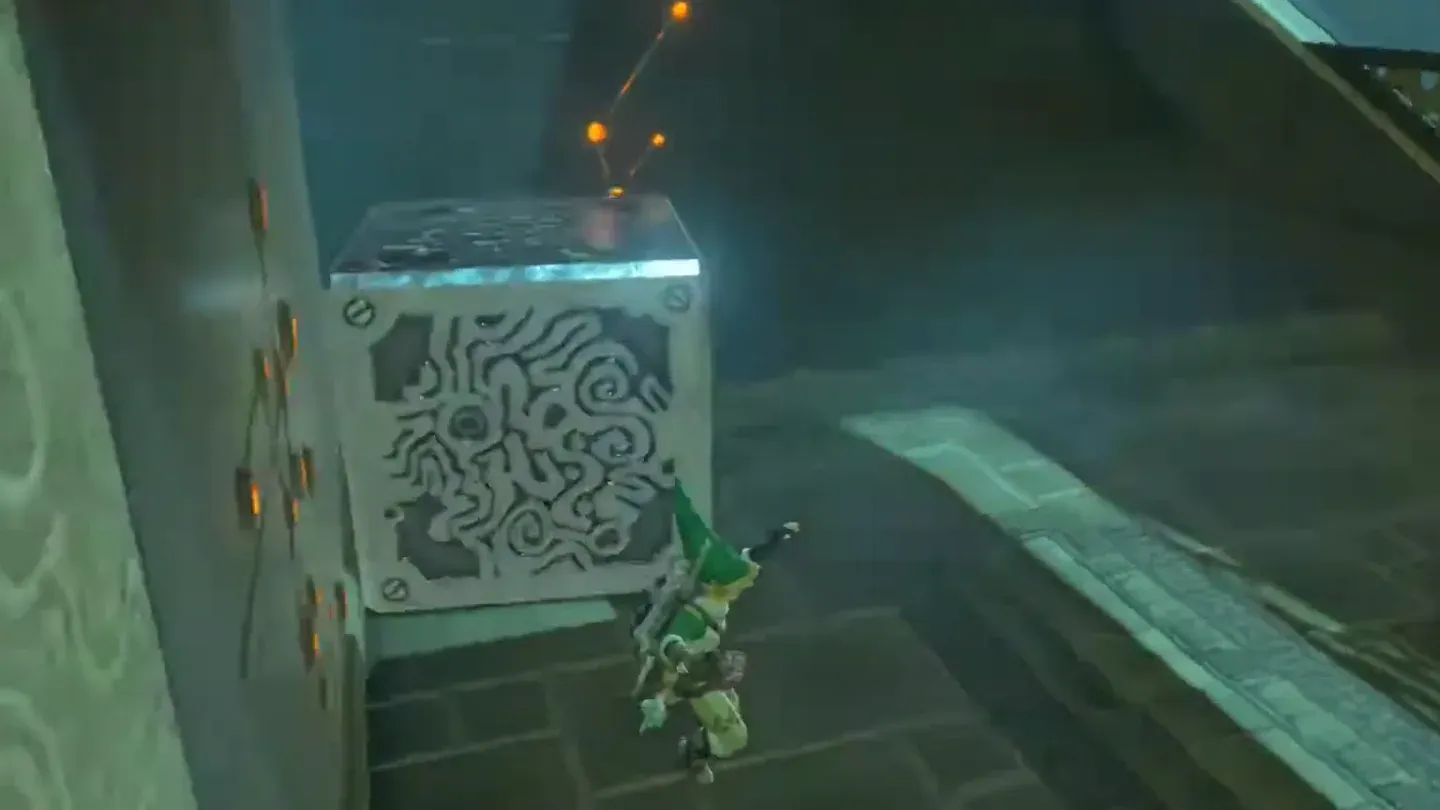The metal cube stacked on the block beside the ramp