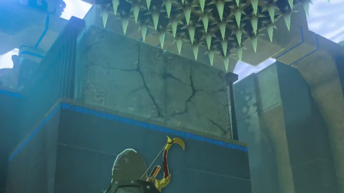 Cracked stone blocks below a row of ceiling spikes