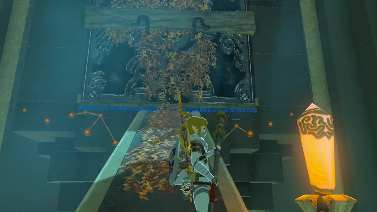Orange foliage covering the barrier in front of the metal doors