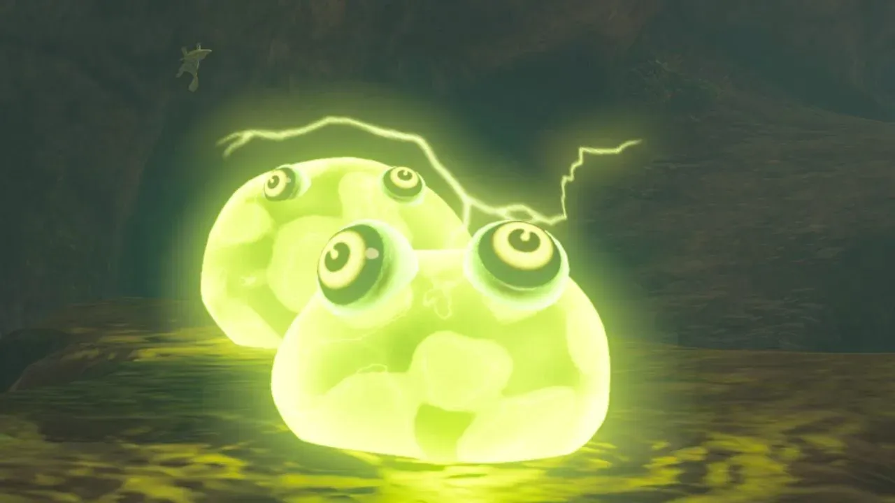 Two glowing yellow-green Electric Chuchus with electricity arcing above them in a dark place