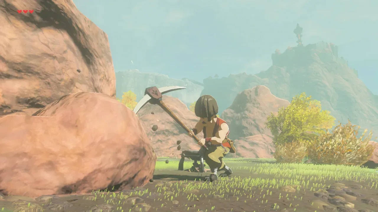 Hudson swinging a pickaxe at a large boulder