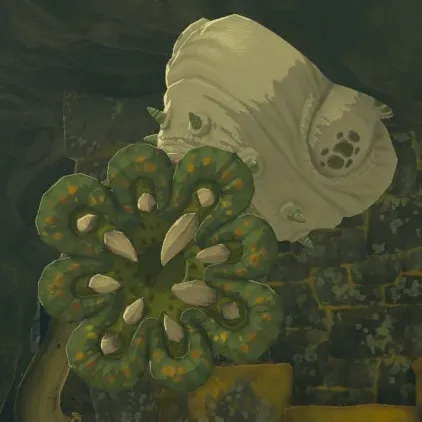 A Like Like clinging to a cave wall, its pale body behind a green flower-shaped mouth ringed with white teeth