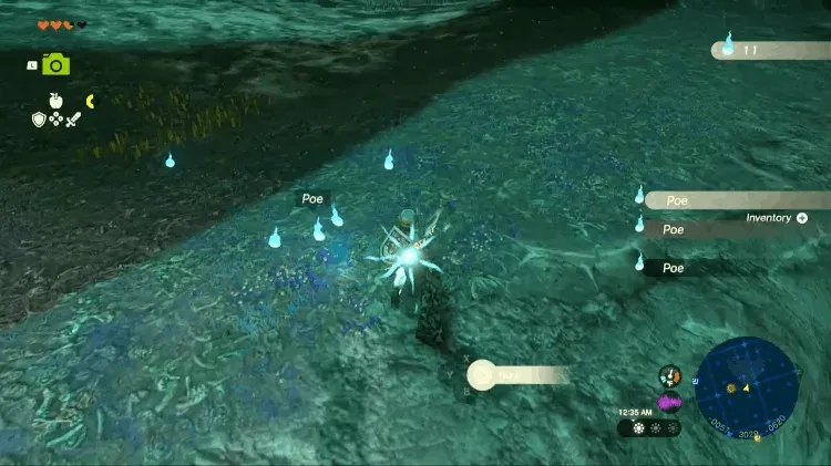 Link picking up a group of blue Poes on the ground in the Depths