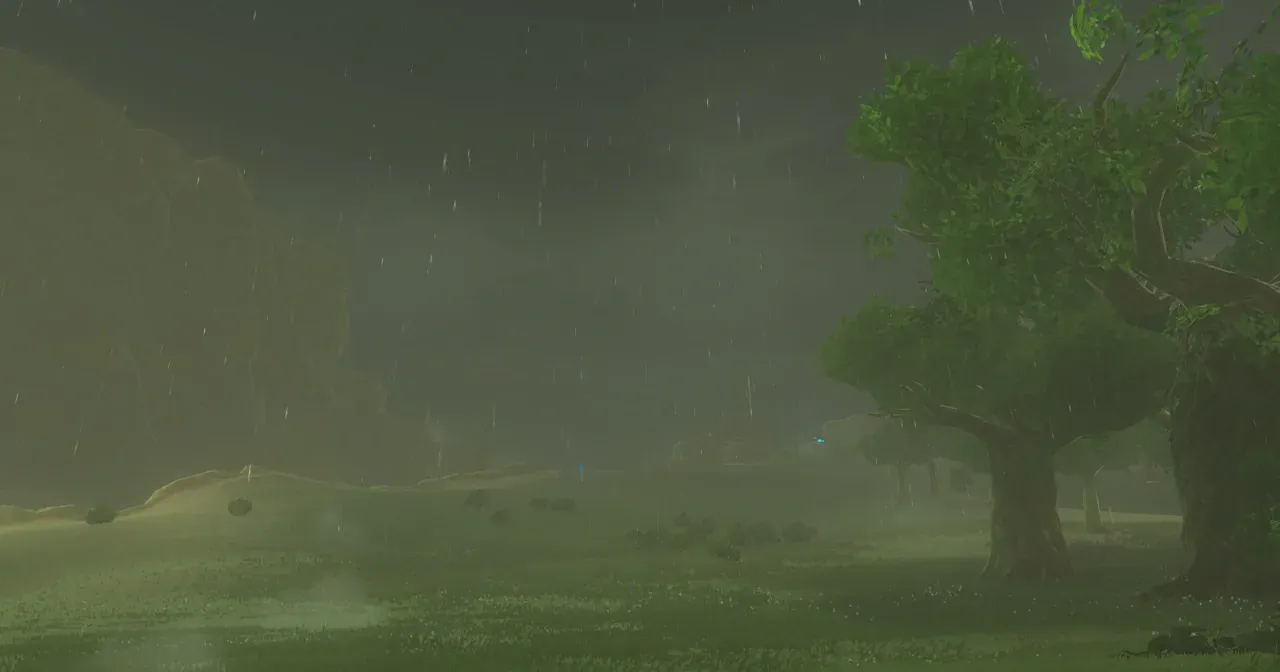 下雨中的原野和樹林，雨幕讓遠處變得模糊