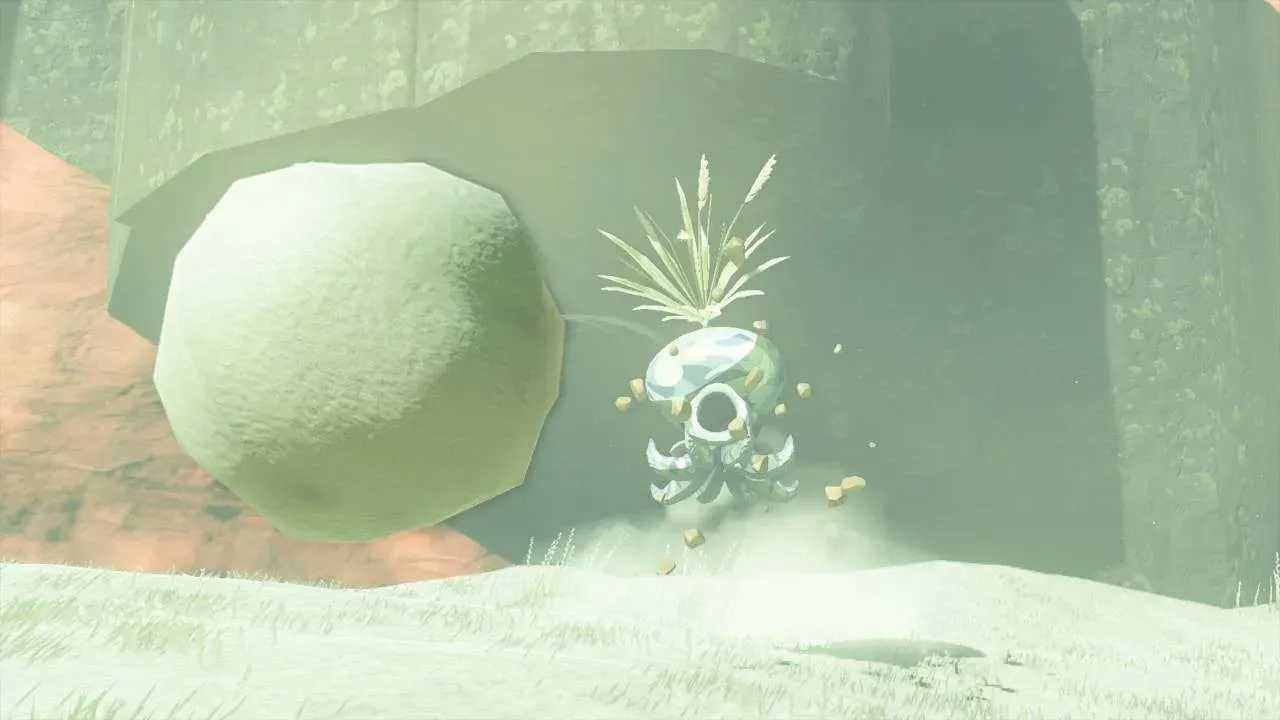 A pale Snow Octorok with dry grass on its head spitting a large snowball