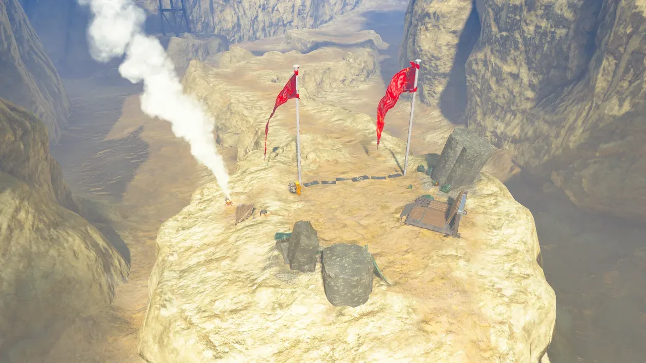 Two red flags on a sandy ledge in Tanagar Canyon, with a box and stone blocks nearby