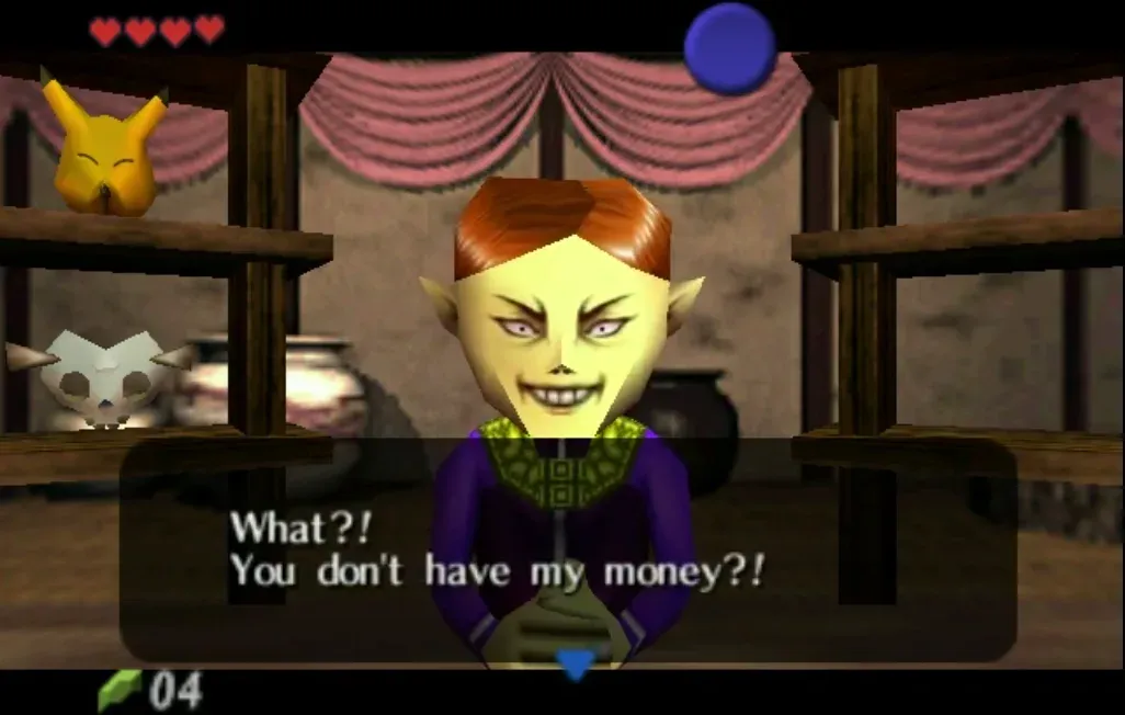 The Happy Mask shopkeeper leaning forward with an angry grin above the words What?! You don't have my money?!, with the Keaton Mask and Skull Mask on the shelf behind him