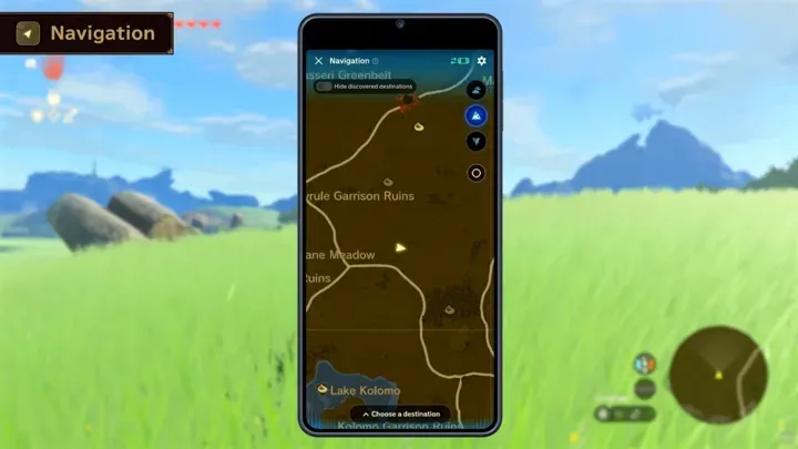 A phone showing a game map over a gameplay screen